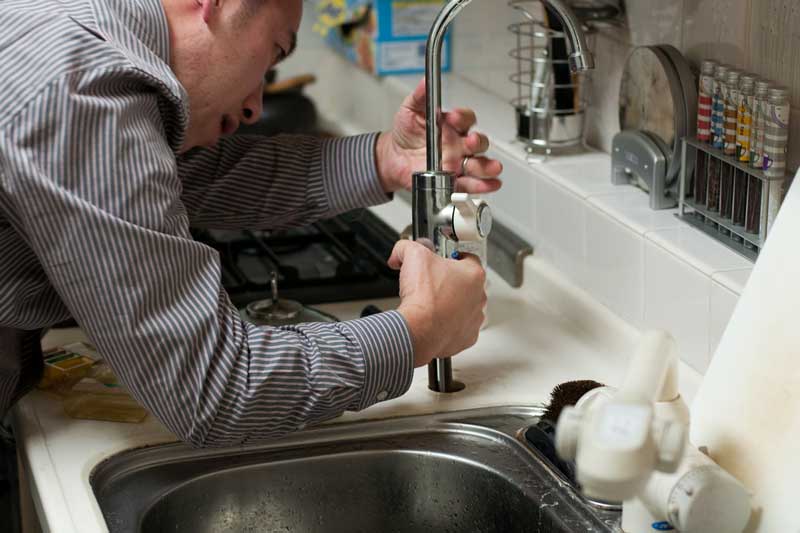 A plumber fixing a faucet